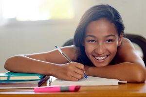 Portrait of a young schoolgirl doing her homework in class