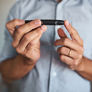 man checking his blood sugar from finger